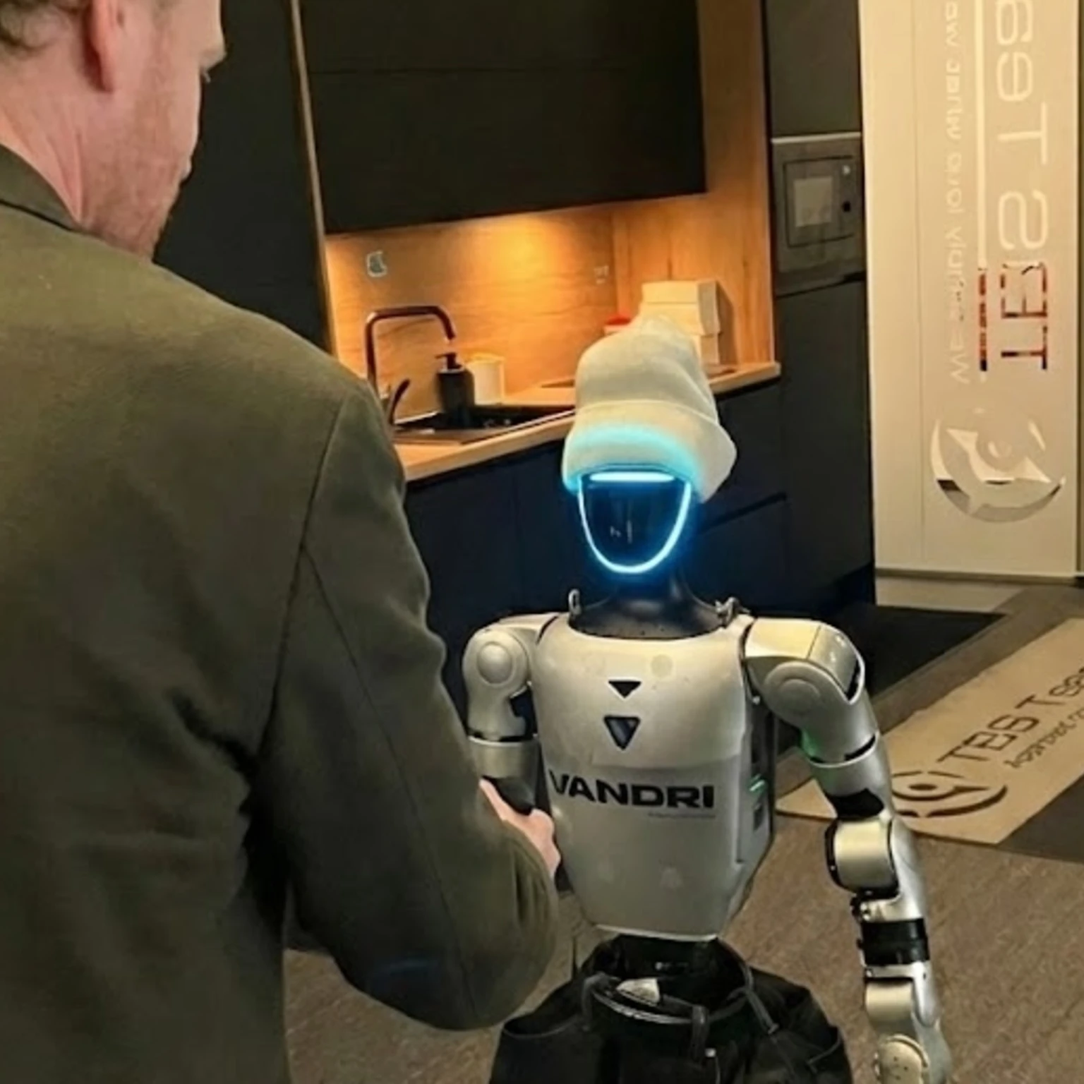 Roland Obermair shaking hand of Jože, the humanoid robot